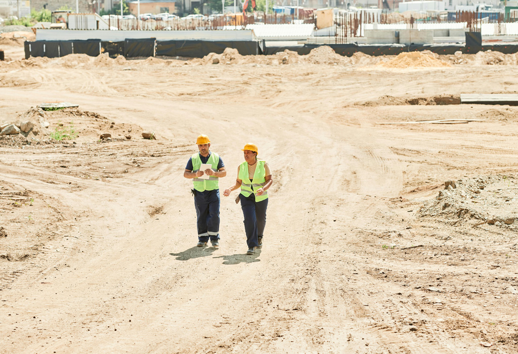 Construction workers at a residential building site with framing and scaffolding, symbolizing quality oversight and modern home development.